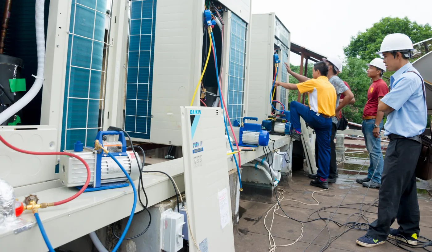 Technicians installing an air-conditioning unit